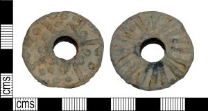 Stone or iron discs with a hole in the center, measuring 2-3 centimeters in diameter