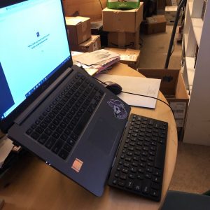 Laptop on a stand that raises monitor to eye level with separate wireless keyboard and mouse