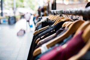 Low angle photograph of clothing on hangers, with an indistinct background